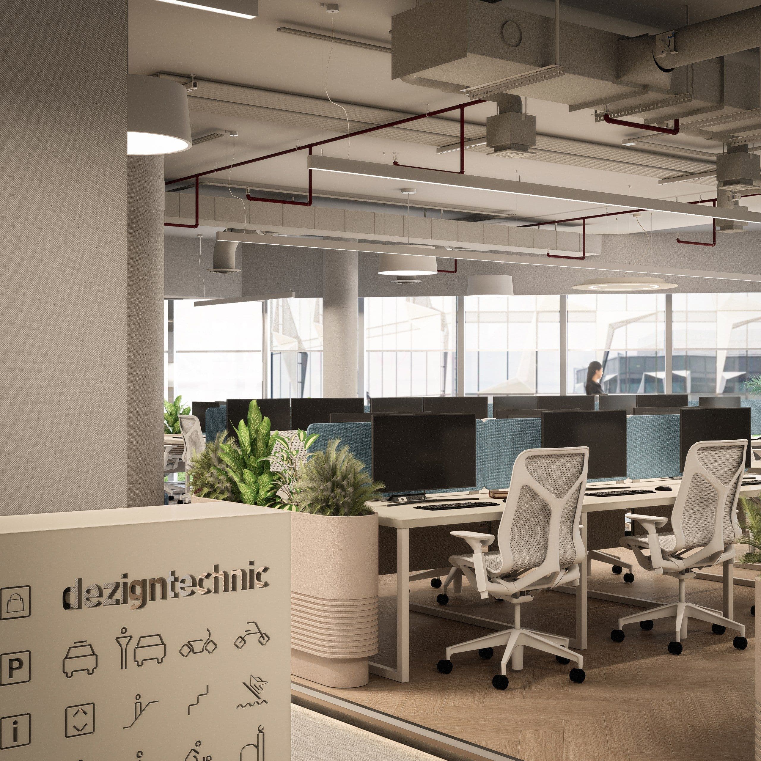 Reception counter carrying the Dezigntechnic logo, with planting beside the desks