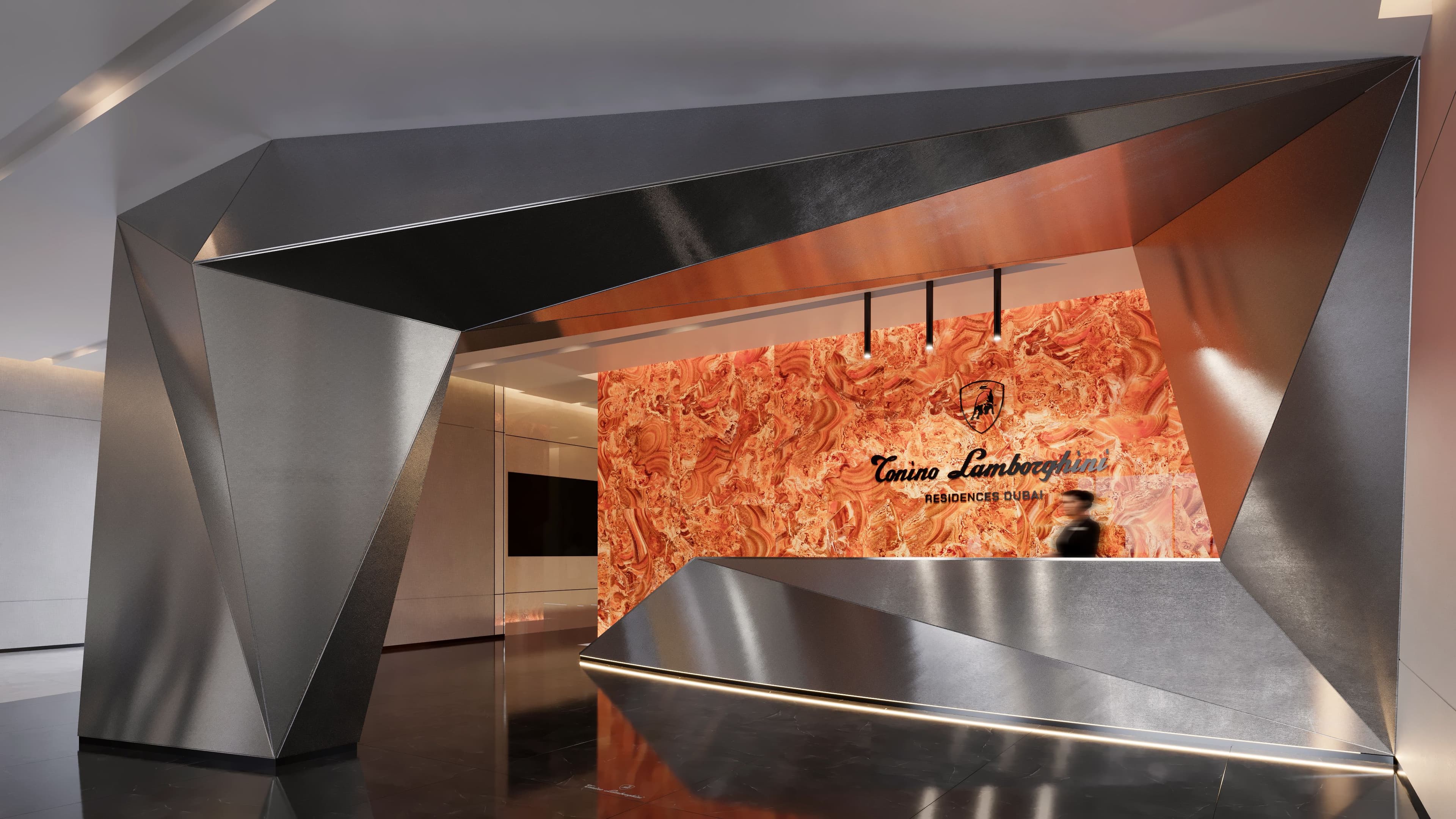 Faceted dark metal reception wall with a backlit orange marble panel carrying the Tonino Lamborghini name