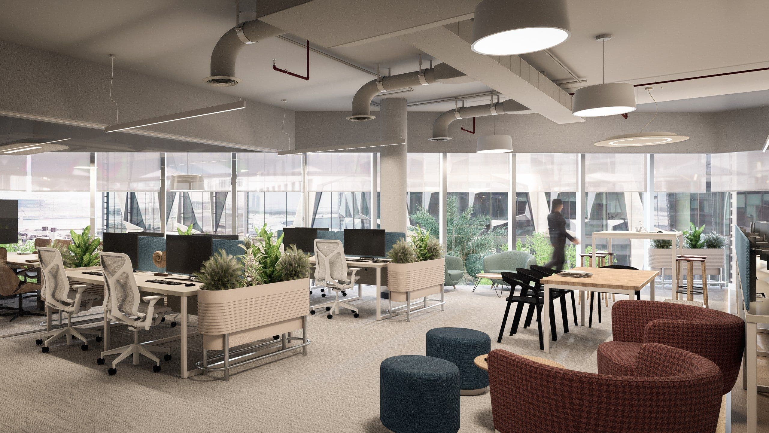 Open plan desks with planters, armchairs and exposed services overhead