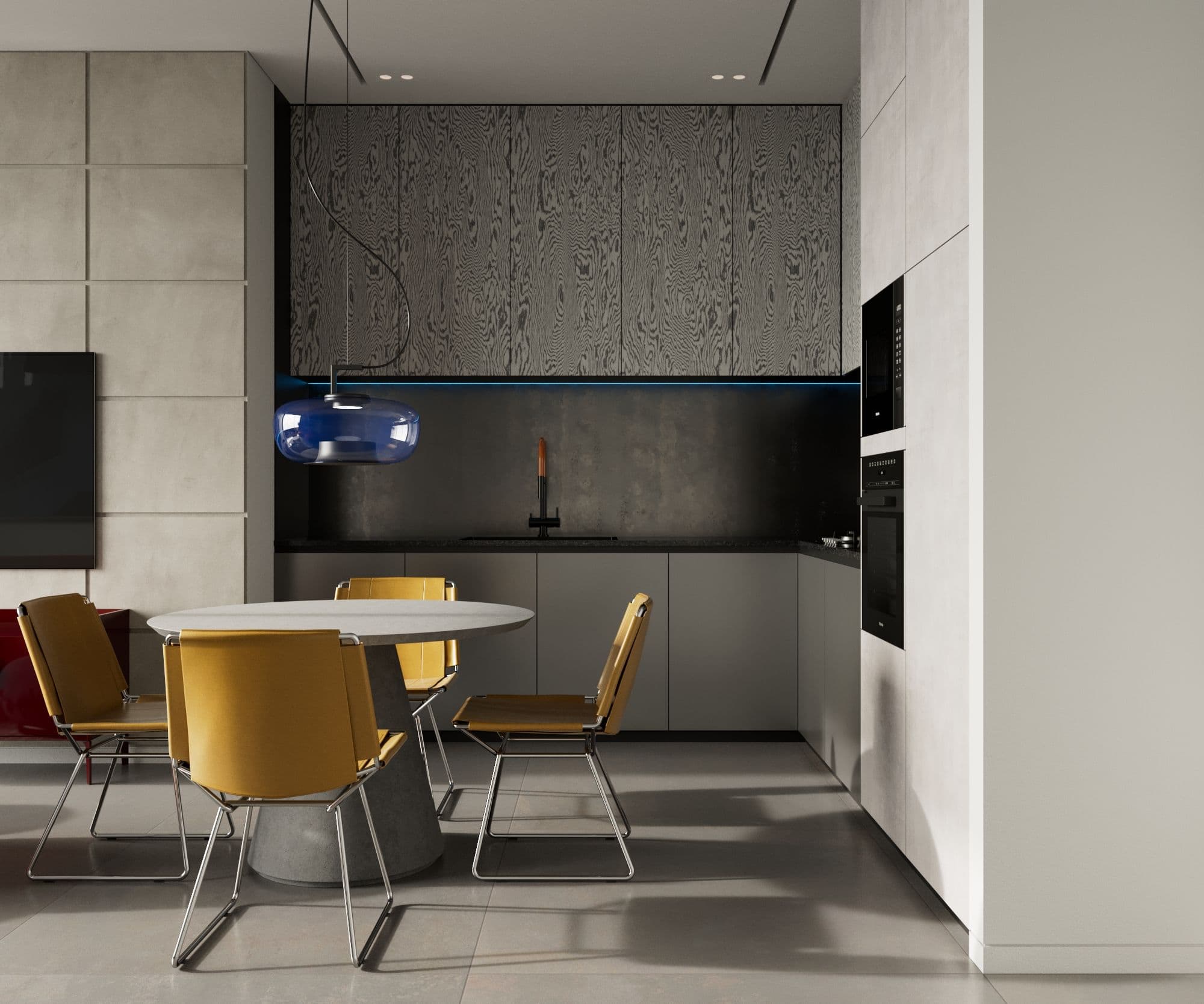 Kitchen in dark stone and pale cabinetry with a round dining table and mustard chairs